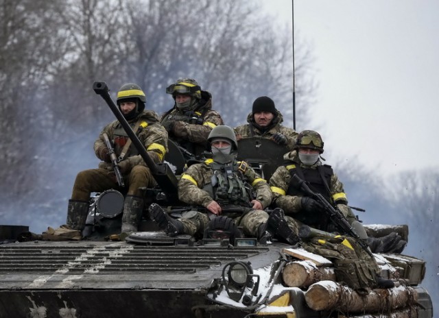 Members of the Ukrainian armed forces ride on an armoured personnel carrier (APC) near Debaltseve