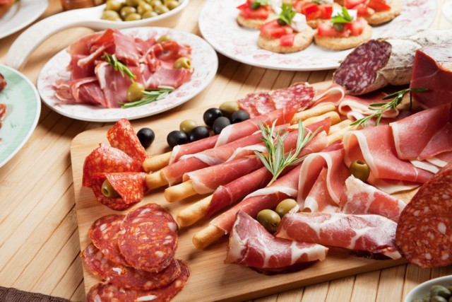 Italian prosciutto, cured pork meat on cutting board