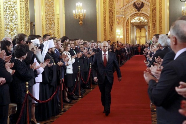 Putin walks as he attends inauguration ceremony at Kremlin in Moscow